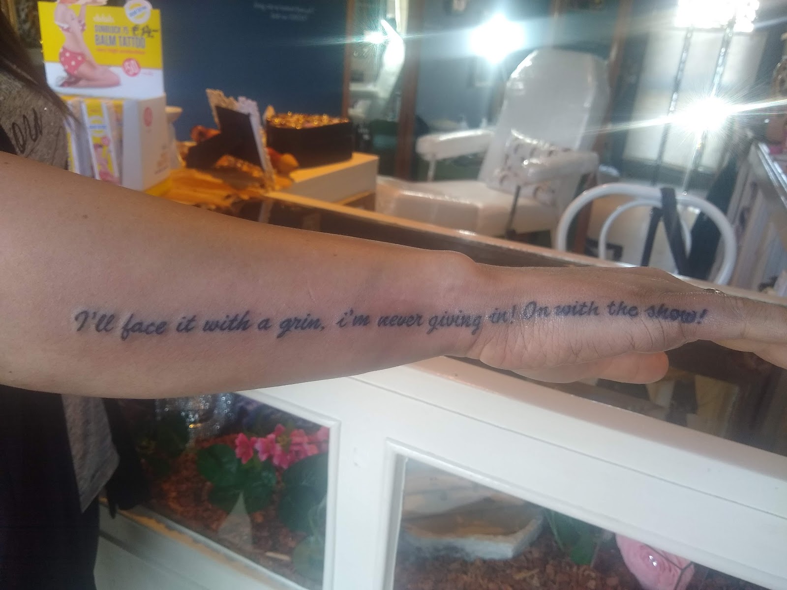 Belettering tattoo met sierlijke tekst op de onderarm